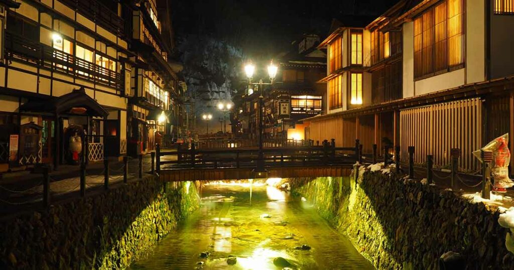 Ginzan Onsen ist von historischen Holzhäusern und einem reißenden Fluss umgeben. Es strahlt eine wunderschöne nostalgische Atmosphäre aus.